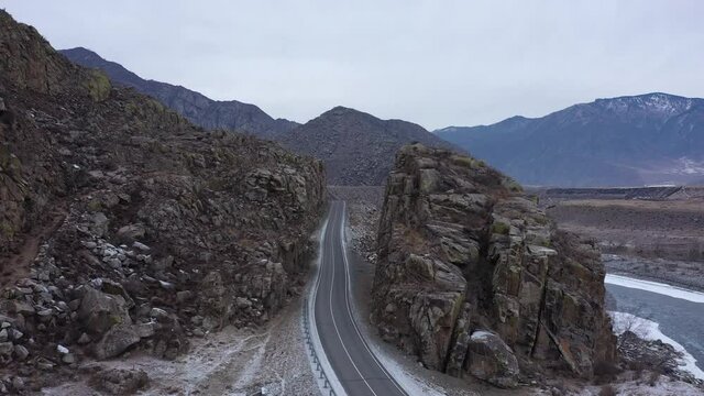 Scenic road made between rocks. Aerial view of asphalt road at Altai Republic. Modern silk path - Chuiskiy trakt