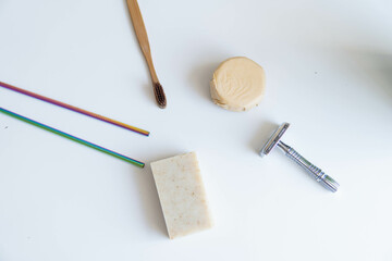 Zero waste product, close up caption. Bamboo toothbrush, solid shampoo, metal razor, metal straws and solid hand soap. Sustainable bathroom products on a white background.