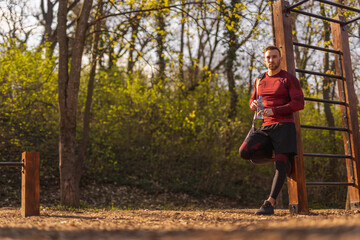 Obraz premium Man holding bottle of water and carrying gym bag after outdoor workout