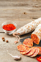 Sliced Chorizo Sausage with spices on wooden board