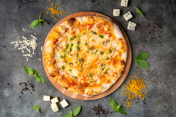 Delicious Italian 4 cheese pizza on dark background. With ingredients. Traditional Italian food....