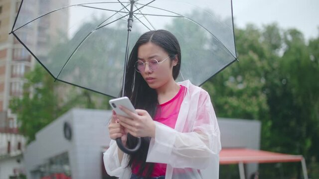 Asian woman tourist studying map in smartphone application looking for right way