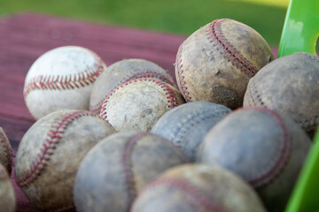 old vintage dirty baseballs dropped from a bucket