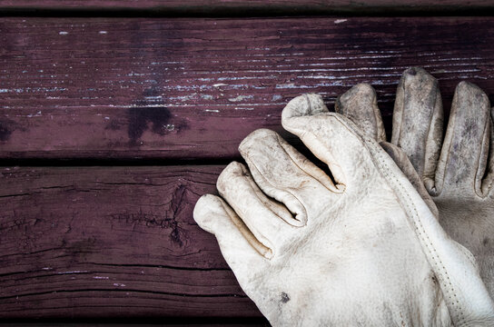 leather garden gloves on a red picnic table