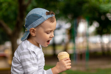little cute boy ready to eat ice cream outside.close-up.