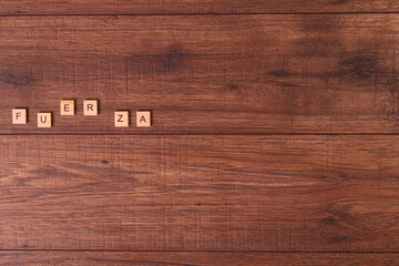 Frases motivadoras con letras naturales sobre una mesa o suelo de madera rustica.