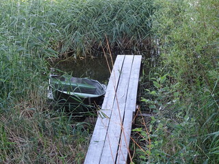 Wooden walkways by the lake and an empty boat nearby