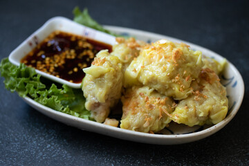 boiled dumpling or gyoza stuffed mashed pork and shrimp with  topping fried chop garlic on plate dipping sweet soybean sauce
