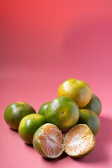 Tangerines piled on a pink background