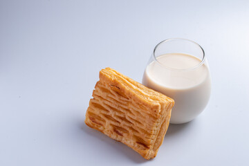 Pineapple pie with fresh milk in a clear glass on a white background.