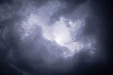 Obraz premium Dark and stormy clouds layered with pop of light.