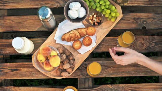 Top view of a table full of food and drinks, man and woman taking it. Glamping, Slow motion
