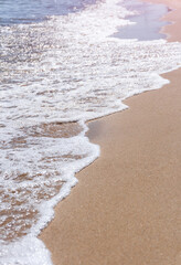 Coastline. Sea waves with white foam and sandy beach. close-up. background.