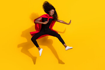 Fototapeta na wymiar Full length body size photo curly girl jumping fighting ninja wearing red cover super woman isolated vivid yellow color background