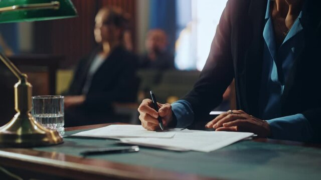 Court of Justice and Law Trial: Female Public Defender Writes Down Arguments for Defence Strategy. Successful Attorney Lawyer Fight for Freedom of Her Client with Supporting Evidence. Close Up.