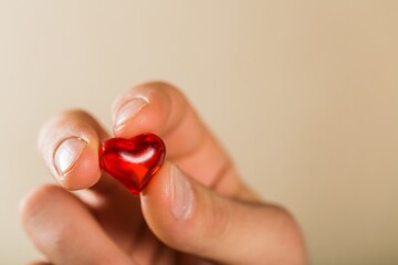 love concept. holding a small red heart in hands.