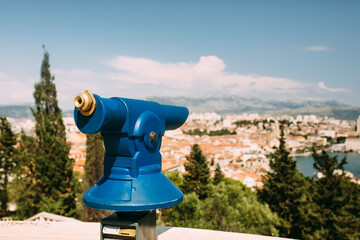 Touristic view on a coastal town from the observation point on the hill with the coin operated spyglass