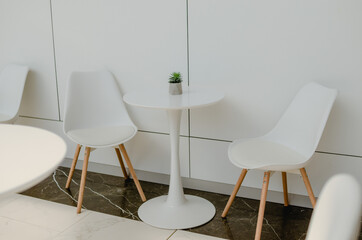 White table and chairs. Cafe interior in light colors.