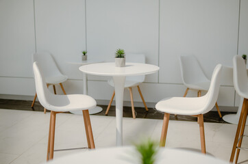 White table and chairs. Cafe interior in light colors.