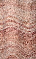 Textured Sandstone with Curving Lines in Red and Pink on a Rough Flat Surface
