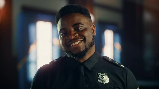 Authentic Portrait of Happy and Handsome Black Policeman in Universal Uniform Smiling at Camera. Successful African American Law Enforcement Agent. Courtroom Security Guard at Work. Cinematic Footage.