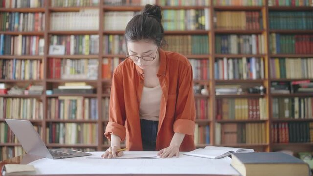 Landscape designer taking measurements of template and entering data into laptop