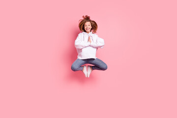 Full length body size girl jumping high practising yoga in white hoodie isolated pastel pink color background
