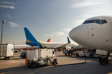 View of white airplane during refueling at airport outdoors on a daytime. Aircraft details. Plane,...