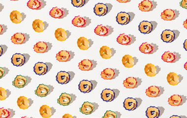 Colorful pencil shavings with sharp shadows on bright background. Back to school pattern.