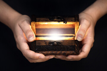 old pirate chest in hands and white light from it, pirate mystery, concept of magic, fairy tale,...
