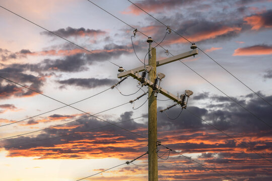 Transmission lines on a power pole at sunset in Alberta Canada.