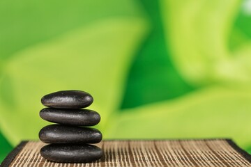 Balancing Pebbles black stones on green background