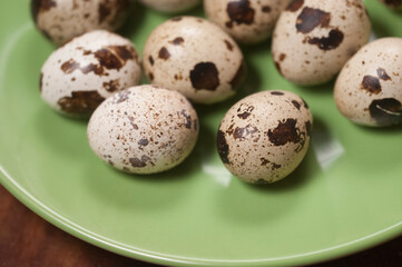 Obraz premium Quail eggs on a green ceramic plate