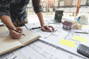 an architect looking the whole schematic blueprint revising the details of the structure