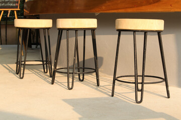 The wooden chair stool in front of the concrete counter.