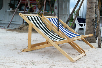 Beach chairs and umbrella on white sand beach.