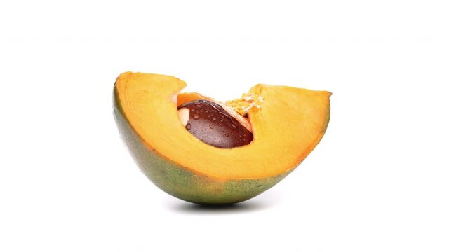 Lucuma fruit slice rotating on white background.