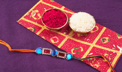 Raksha Bandhan festival Concept showing designer Rakhi or Wrist Band showing details over colourful background. Symbol of love between Brothers and Sisters. Selective focus.
