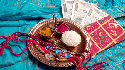 Raksha Bandhan festival Concept showing designer Rakhi or Wrist Band showing details over colourful background. Symbol of love between Brothers and Sisters. Selective focus.
