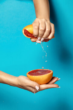 Woman squeezing fresh juicy grapefruit