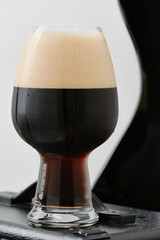 Guitar with black electric guitar and glass of stout beer against on a white wall. Selective focus
