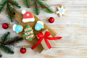 Christmas composition with gingerbread and gift box on the cutting board  on the wooden background. Top view. Copy space.