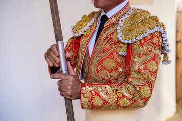 Unrecognizable bullfighter in traditional costume standing with lance