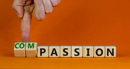 Passion or compassion symbol. Businessman turns cubes, changes the word compassion to passion. Beautiful orange table, orange background, copy space. Business, passion or compassion concept.