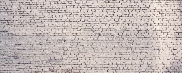 Panoramic view of grunge white brick wall of old facility facade.