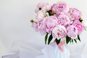 Bouquet of pink peonies in a white vase. Close-up, copy space, background, selective focus.