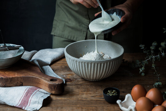 Crop cook adding yogurt to flour
