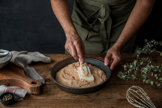 Crop cook spreading batter in tin