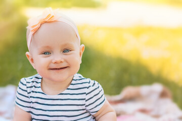 Smiling child in striped dress and bow on his head