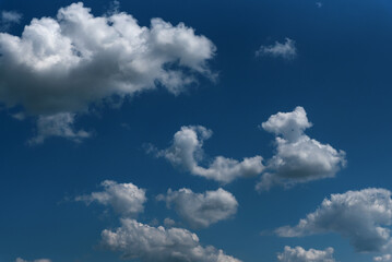 Dark blue sky and white clouds natural background. White cumulus clouds in the blue sky.